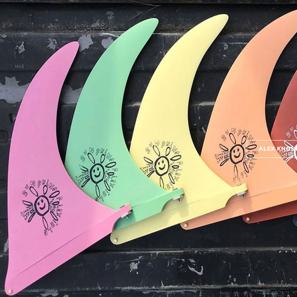 Four colorful plastic tools with sun designs on a black surface