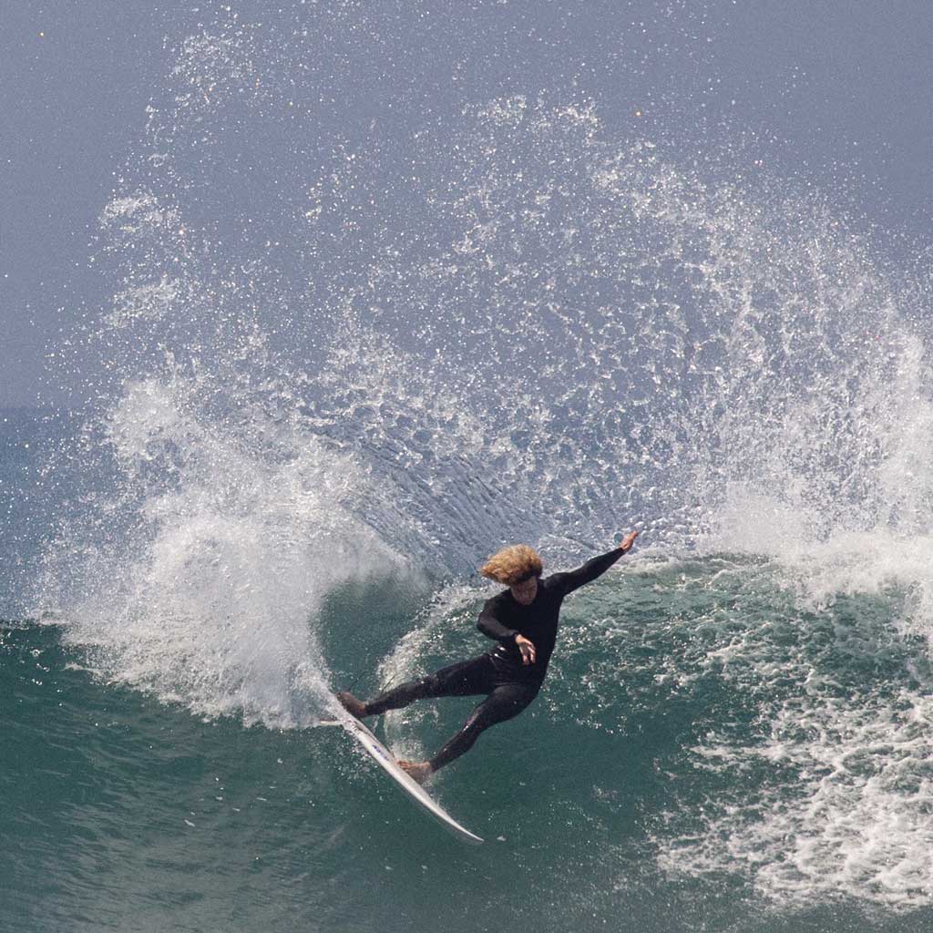 Person surfing on a wave with a clear sky background