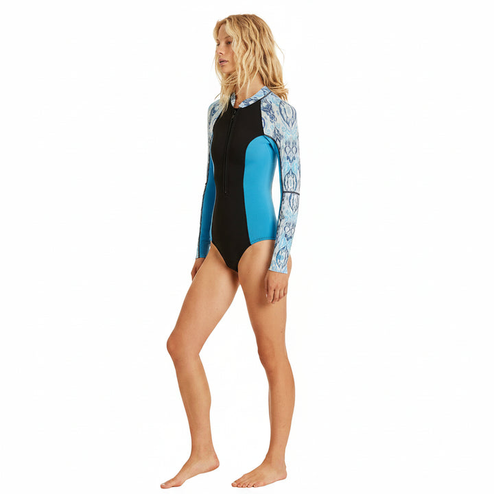 Woman wearing a black and blue swimsuit with floral pattern on a beige background